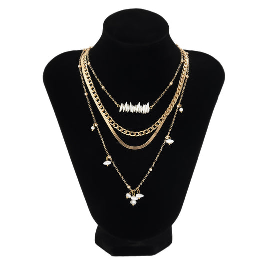 Multilayer chain necklace with shell and pearl embellishments